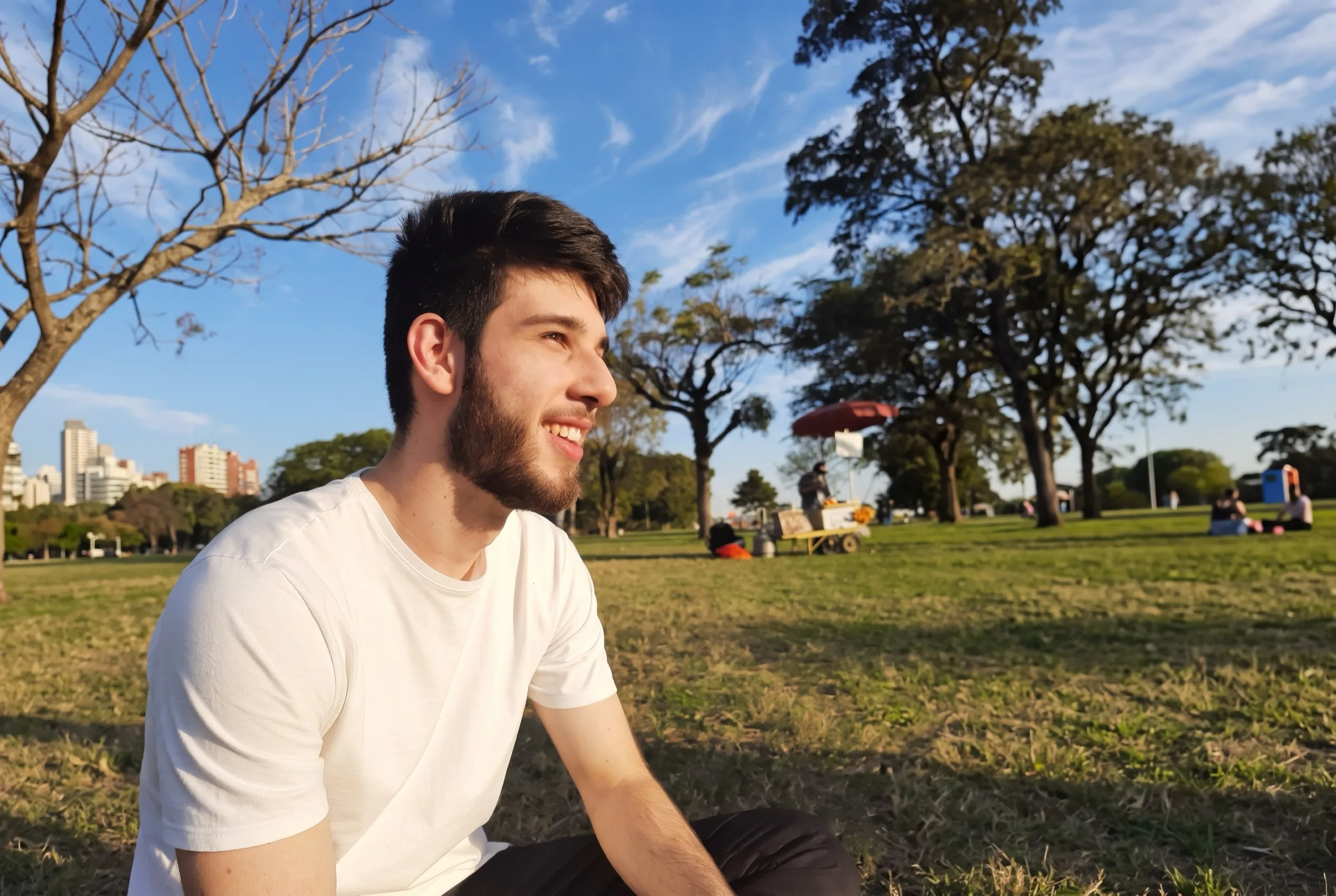 Artur Webber sitting outside, smiling and looking off to the side